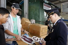 Hải quan cửa khẩu Móng Cái kiểm tra hàng nhập khẩu. (Ảnh: Phạm Hậu/TTXVN)