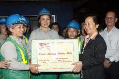 Phó Chủ tịch nước Nguyễn Thị Doan tặng quà cho công nhân Tổ môi trường số 8 - Chi nhánh Hai Bà Trưng. (Ảnh: Trọng Đức/TTXVN)