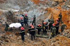 Chuyển thi thể nạn nhân thứ 5 ra khỏi hiện trường vụ sạt lở bãi thải mỏ than Phấn Mễ. (Ảnh: Hằng Anh/TTXVN)
