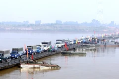 Các phương tiện giao thông đi trên cầu phao. (Ảnh: Trọng Đức/TTXVN) 