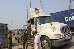 Lực lượng cứu hộ di chuyển chiếc xe gặp tai nạn rời khỏi hiện trường. (Ảnh: Anh Tuấn/Vietnam+)