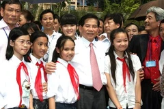 Chủ tịch nước Nguyễn Minh Triết với các cháu thiếu nhi đất Tổ. (Ảnh: Nguyễn Khang/TTXVN) 