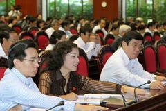 Các đại biểu Quốc hội ấn nút thông qua các Nghị quyết. (Ảnh: Nhan Sáng/TTXVN)