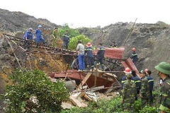 Lực lượng quân đội, công an, công nhân mỏ than khẩn trương đào bới tìm kiếm người bị nạn vụ sạt lở bãi thải Mỏ than Phấn Mễ. (Ảnh: Thảo Nguyên/TTXVN)