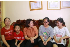 Người thân và hàng xóm đến chia sẻ niềm vui cùng Thu Ngân (áo ghi) và gia đình. (Ảnh: Hải Yến/TTXVN)