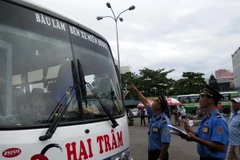 Thanh tra Giao thông kiểm tra các xe về Bến xe miền Đông. (Ảnh: Hoàng Hải/TTXVN)