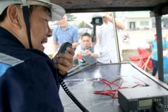 Kiểm tra thiết bị thông tin liên lạc lắp trên tàu cho ngư dân. (Ảnh: Nguyễn Thanh/TTXVN)