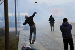 Người biểu tình ném đá về phía cảnh sát. (Nguồn: EPA)