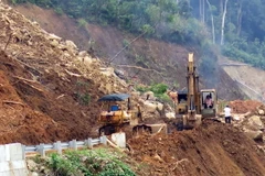 Khắc phục sạt lở trên đường Trường Sơn Đông. (Ảnh: Cao Nguyên/TTXVN)