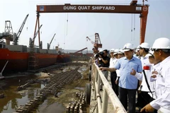 Phó Thủ tướng Lê Minh Khái với các đại biểu khảo sát thực tế tại nhà máy đóng tàu Dung Quất thuộc Công ty Công nghiệp tàu thủy Dung Quất. (Ảnh: An Đăng/TTXVN)