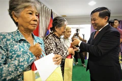 Trao tặng quà, hỗ trợ các gia đình có công, hộ nghèo gốc Việt ở Campuchia vui đón Tết. (Ảnh Huỳnh Thảo/TTXVN)