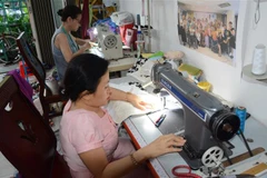 Nhóm phụ nữ khuyết tật đang làm ra những sản phẩm thời trang từ các loại vải thải thu gom được. (Ảnh minh họa: Văn Dũng/TTXVN)
