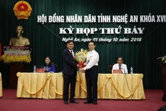 Ông Nguyễn Xuân Sơn - Phó Bí thư Thường trực Tỉnh ủy, Chủ tịch Hội đồng Nhân dân tỉnh tặng hoa chúc mừng ông Thái Thanh Quý. (Ảnh: Bích Huệ/TTXVN)