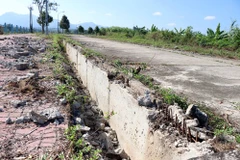 Công trình bị một số đối tượng đập phá hàng loạt lan can, nắp cống thoát nước để lấy sắt bán. (Ảnh: Cao Nguyên/TTXVN)