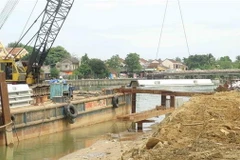 Thi công phần móng kè chống sạt lở bờ sông gây nguy hại đến phố cổ. (Ảnh: Hữu Trung/TTXVN)