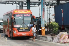 Tài xế tự nhấc barie để đi tại trạm thu phí BOT cầu Tân Đệ. (Ảnh: Thế Duyệt/TTXVN)
