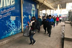 Hành khách lỉnh kỉnh đồ đạc trở về thủ đô sau kỳ nghỉ lễ Tết Dương lịch. (Ảnh: Việt Hùng/Vietnam+)