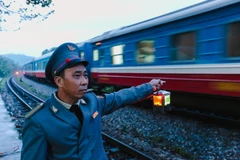 Trong khi chờ đợi đường sắt cao tốc, những nhân viên gác chăn vẫn túc tắc làm việc trên đường sắt khổ 1m đã có tuổi đời hơn 100 năm từ thời Pháp thuộc. (Ảnh: Minh Sơn/Vietnam+) 