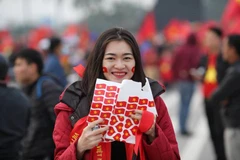 Cổ động viên nữ với băng rôn dán trên mặt sẽ tiếp lửa cho đội tuyển Việt Nam trong trận chung kết AFF Cup. (Ảnh: Minh Sơn/Vietnam+)