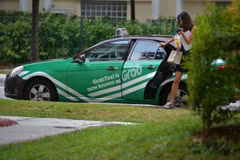 Người dân sử dụng ứng dụng gọi xe của Grab. (Nguồn: straitstimes.com)