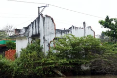 Sạt lở kênh Chợ Gạo làm nhiều ngôi nhà lộ rõ cả chân móng. (Ảnh: Huy Hùng/Vietnam+)