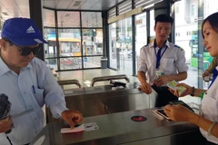 Khách sử dụng thẻ vé điện tử qua cổng kiểm soát để lên xe buýt nhanh BRT 01 Kim Mã-Yên Nghĩa. (Ảnh: Việt Hùng/Vietnam+)