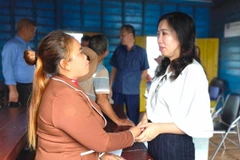 Thứ trưởng Bộ Ngoại giao Lê Thị Thu Hằng (phải) thăm hỏi bà con người gốc Việt tại làng nổi Kbal Tao (xã Koh Chiveang, huyện Ek Phnom, tỉnh Battambang). (Ảnh: TTXVN phát)
