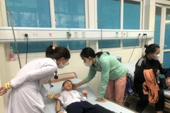 Bác sỹ kiểm tra cho học sinh nhập viện nghi ngộ độc thực phẩm. (Ảnh: TTXVN phát)
