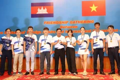 Đại sứ Việt Nam tại Campuchia Nguyễn Huy Tăng trao kỷ niệm chương cho các vận động viên tham gia chương trình giao lưu thể thao. (Ảnh: Hoàng Minh/TTXVN)