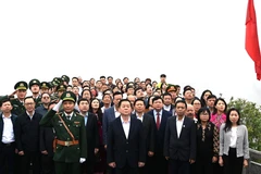 Trưởng Ban Tuyên giáo Trung ương Nguyễn Trọng Nghĩa và các đại biểu thực hiện nghi thức chào cờ tại Cột cờ Quốc gia Lũng Cú. (Ảnh: Minh Tâm/TTXVN)