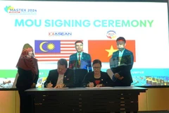 Chủ tịch Hội hữu nghị Malaysia-Việt Nam, Trần Thị Chang (bên trái) ký MoU với Chủ tịch ACCI. (Ảnh: Hằng Linh/TTXVN)