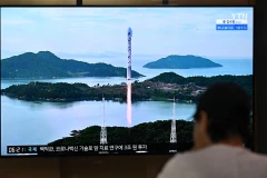 Người dân theo dõi bản tin về vụ phóng vệ tinh của Triều Tiên qua truyền hình ở Seoul, Hàn Quốc ngày 24/8. (Ảnh: AFP/TTXVN)