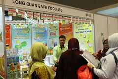 Khách hàng đang tìm hiểu những sản phẩm của công ty Long Quân Save Food Việt Nam. (Ảnh: Hải Ngọc/Vietnam+)