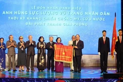 Thủ tướng Nguyễn Xuân Phúc trao tặng danh hiệu Anh hùng Lực lượng vũ trang nhân dân thời kỳ kháng chiến chống Mỹ, cứu nước của Chủ tịch nước cho Đài Phát thanh Giải phóng. (Ảnh: Thống Nhất/TTXVN)