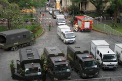 Lực lượng chức năng dẫn giải các bị cáo trong vụ án đặt bon xăng tại Sân bay Tân Sơn Nhất, ngày 27/12/2017. (Ảnh: Thành Trung/TTXVN)