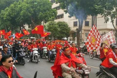 Cổ động viên diễu hành cổ vũ cho đội tuyển Việt Nam trên phố Hai Bà Trưng. (Ảnh: Hoàng Hùng/TTXVN)