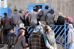 Người dân xếp hàng đợi nhận khẩu phần ăn tại một trung tâm cứu trợ ở thủ đô Sanaa, Yemen. (Ảnh: THX/TTXVN)