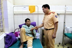 Lãnh đạo Phòng Cảnh sát giao thông Công an tỉnh Điện Biên thăm, động viên trung úy Cà Văn Mạnh tại Bệnh viện Đa khoa tỉnh Điện Biên, sáng ngày 8/6/2018. (Ảnh: Nguyễn Xuân Tiến/TTXVN)