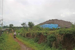 Bãi tập kết chất thải của công ty rất gần với khu dân cư nhưng không có tường rào che chắn. (Ảnh: Nguyễn Dũng/TTXVN)