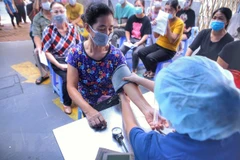Khám sàng lọc cho người dân trước khi tiêm chủng. (Ảnh: Tuấn Đức/TTXVN)
