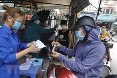 Lực lượng chức năng (công an xã, dân quân tự vệ, đoàn thanh niên) xã Thọ Xuân, huyện Đan Phượng, Hà Nội tham gia trực chốt tại chợ, đảm bảo các quy định về phòng, chống dịch. (Ảnh: Minh Quyết/TTXVN)