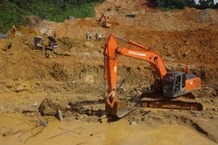 Sử dụng máy xúc đẩy nhanh tiến độ tìm kiếm. (Ảnh: TTXVN phát)