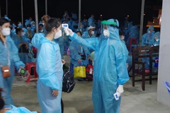 Đo thân nhiệt cho công dân trước khi tiếp nhận. (Ảnh minh họa: Chanh Đa/TTXVN)