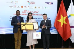 Phó Tổng giám đốc TTXVN Lê Quốc Minh và Trưởng đại diện khu vực châu Á-Thái Bình Dương của Tổ chức quốc tế Pháp ngữ OIF Chékou Oussouman trao giải Nhất cho tác giả Man Khánh Ly. (Ảnh: Hoàng Hiếu/TTXVN)