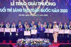 Chủ tịch MTTQ Trần Thanh Mẫn (bên phải) và Bí thư thứ nhất Trung ương Đoàn, Chủ tịch Hội LHTN Việt Nam Nguyễn Anh Tuấn (bên trái) trao Bằng khen tặng các tác giả và nhóm tác giả tại buổi lễ. (Ảnh: Văn Điệp/TTXVN)