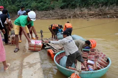 Các nhà tài trợ vận chuyển quà qua suối để cứu trợ cho người dân xã miền núi Vĩnh Ô, huyện Vĩnh Linh, Quảng Trị do giao thông bị chia cắt. (Ảnh: Hồ Cầu/TTXVN)