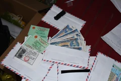 Tang vật và tài liệu vụ án. (Ảnh: Phúc Sơn/TTXVN)