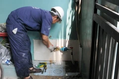 Thi công, lắp đặt mới đồng hồ nước miễn phí cho người dân tại Khu phố 7, phường Thạnh Xuân, quận 12. (Ảnh: An Hiếu/TTXVN)