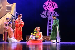 Cụ Thông (Nghệ sỹ nhân dân Lê Khanh, áo đỏ) và con dâu (diễn viên Khuất Quỳnh Hoa áo xanh) mải mê dốc tiền cho những hoạt động mê tín dị đoạn. (Ảnh: Minh Anh/Vietnam+)