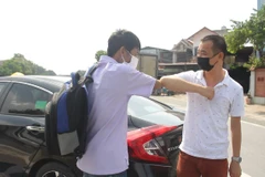 Anh Nguyễn Bình Minh (phải), người sáng lập 'Những chuyến xe yêu thương' tiếp sức cho bệnh nhân về quê mùa dịch. (Ảnh: Minh Anh/Vietnam+)